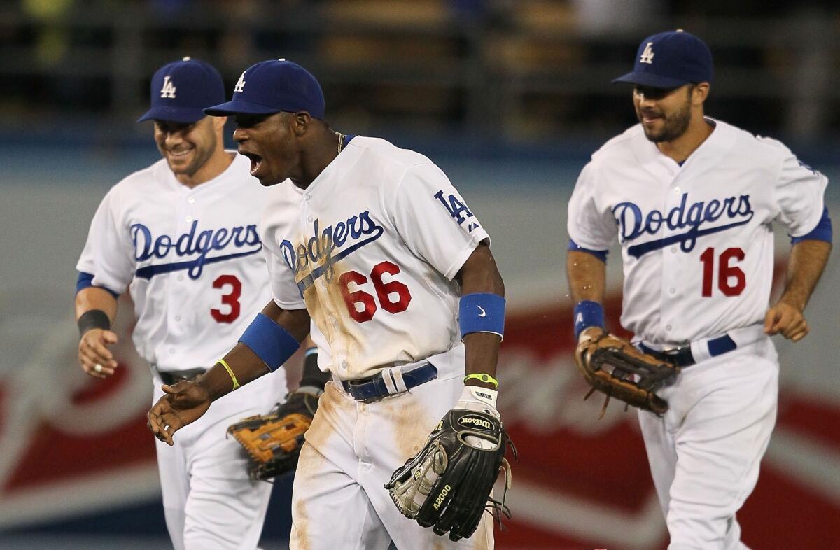 Dodgers right fielder Yasiel Puig, center, celebrates with left fielder Skip Schumaker, left, and center fielder Andre Ethier following their 3-1 victory over the San Francisco Giants.