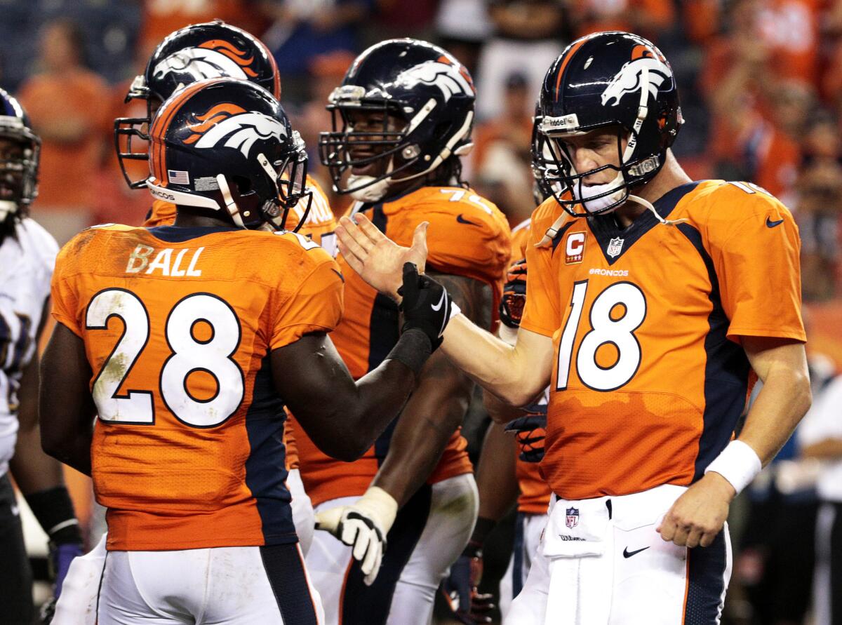 Denver Broncos quarterback Peyton Manning greets teammate Montee Ball as time expires in their 49-27 victory over the then-defending Super Bowl champion Baltimore Ravens in the NFL's 2013 opening game on Sept. 5.