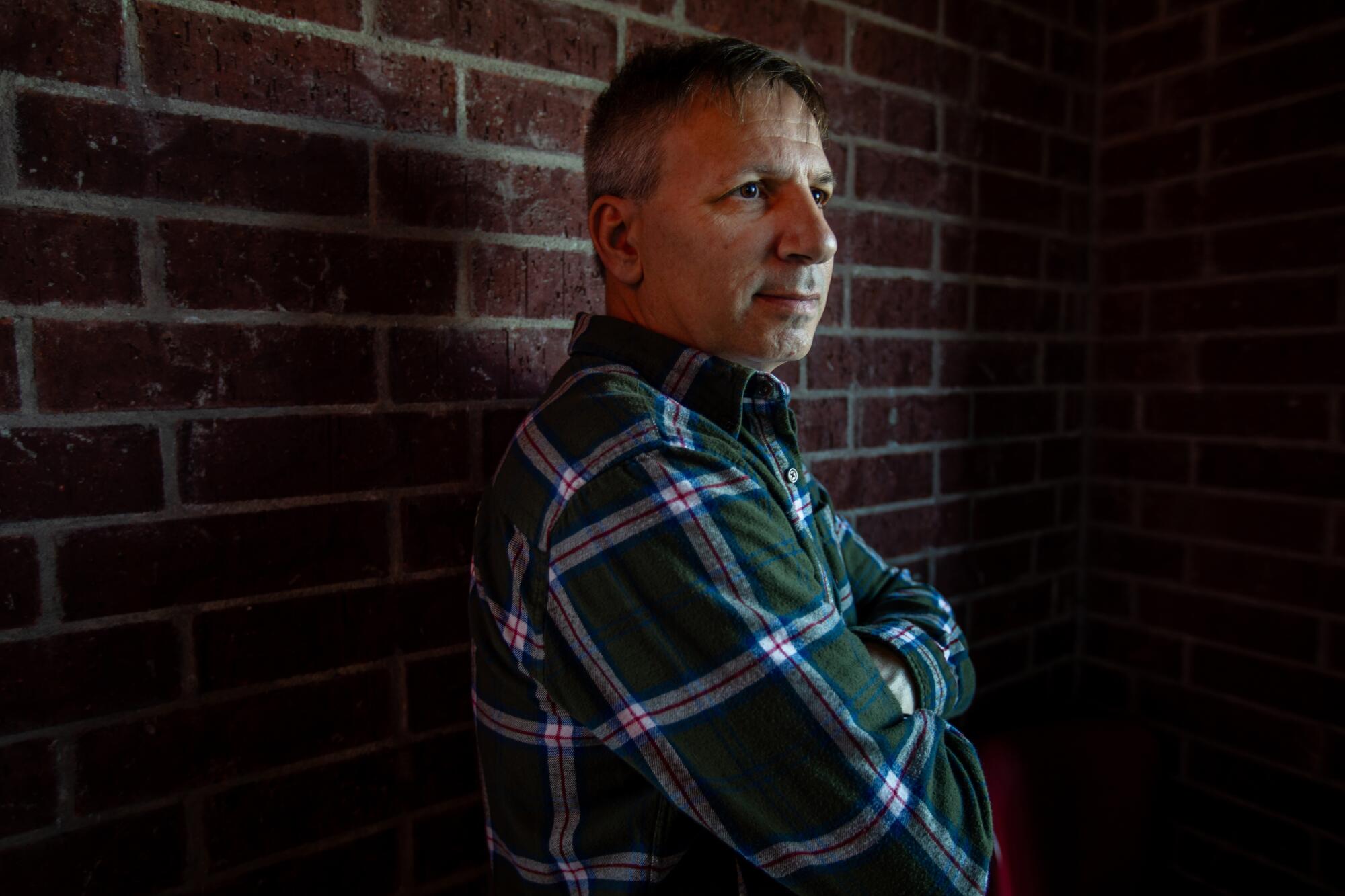 Jamie Abruzzo standing beside a brick wall