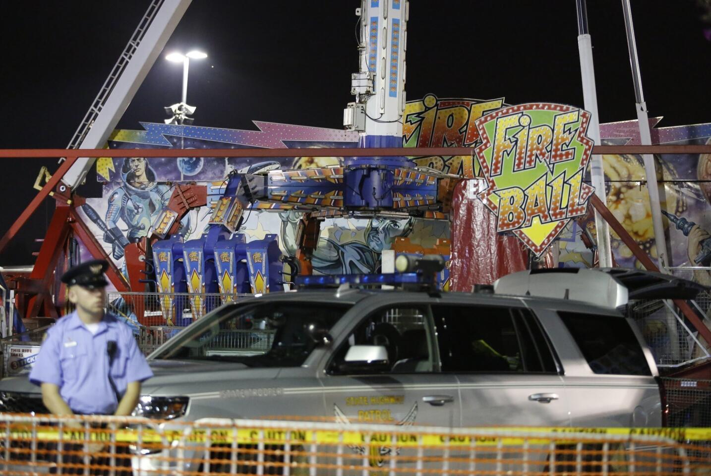 Authorities stand near the Fire Ball amusement ride after the ride malfunctioned injuring several at the Ohio State Fair, Wednesday, July 26, 2017, in Columbus, Ohio. Some of the victims were thrown from the ride when it malfunctioned Wednesday night, said Columbus Fire Battalion Chief Steve Martin.