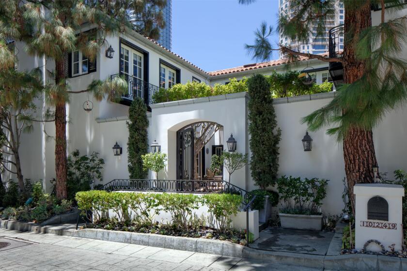 One of 36 homes in a guard-gated enclave, the two-story villa is navigated by an elevator and sweeping staircase.