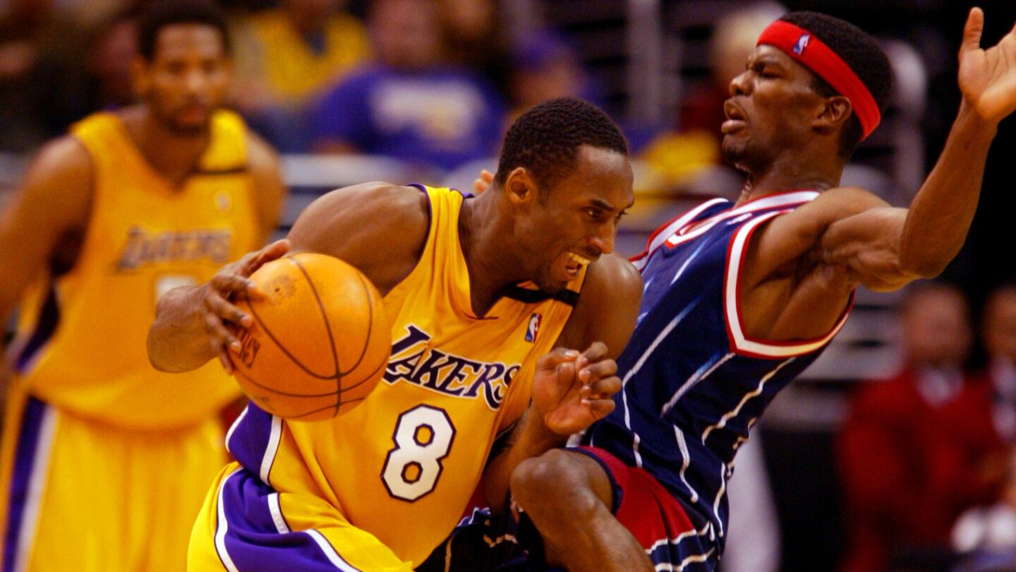 Lakers star Kobe Bryant, left, drives on Houston Rockets small forward Juaquin Hawkins during a game at Staples Center on Nov. 17, 2002.