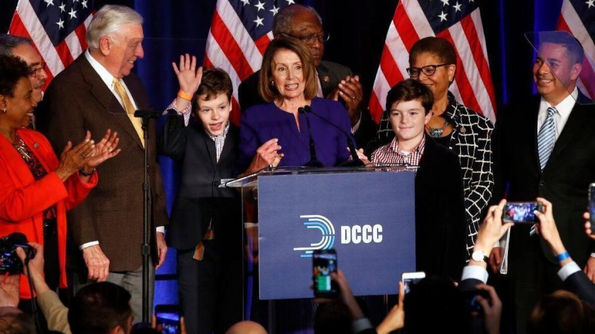 Nancy Pelosi speaks between two of her grandsons and congressional Democrats as they celebrate Democratic wins in the House of Representatives at the Hyatt Regency Hotel in Washington, D.C.