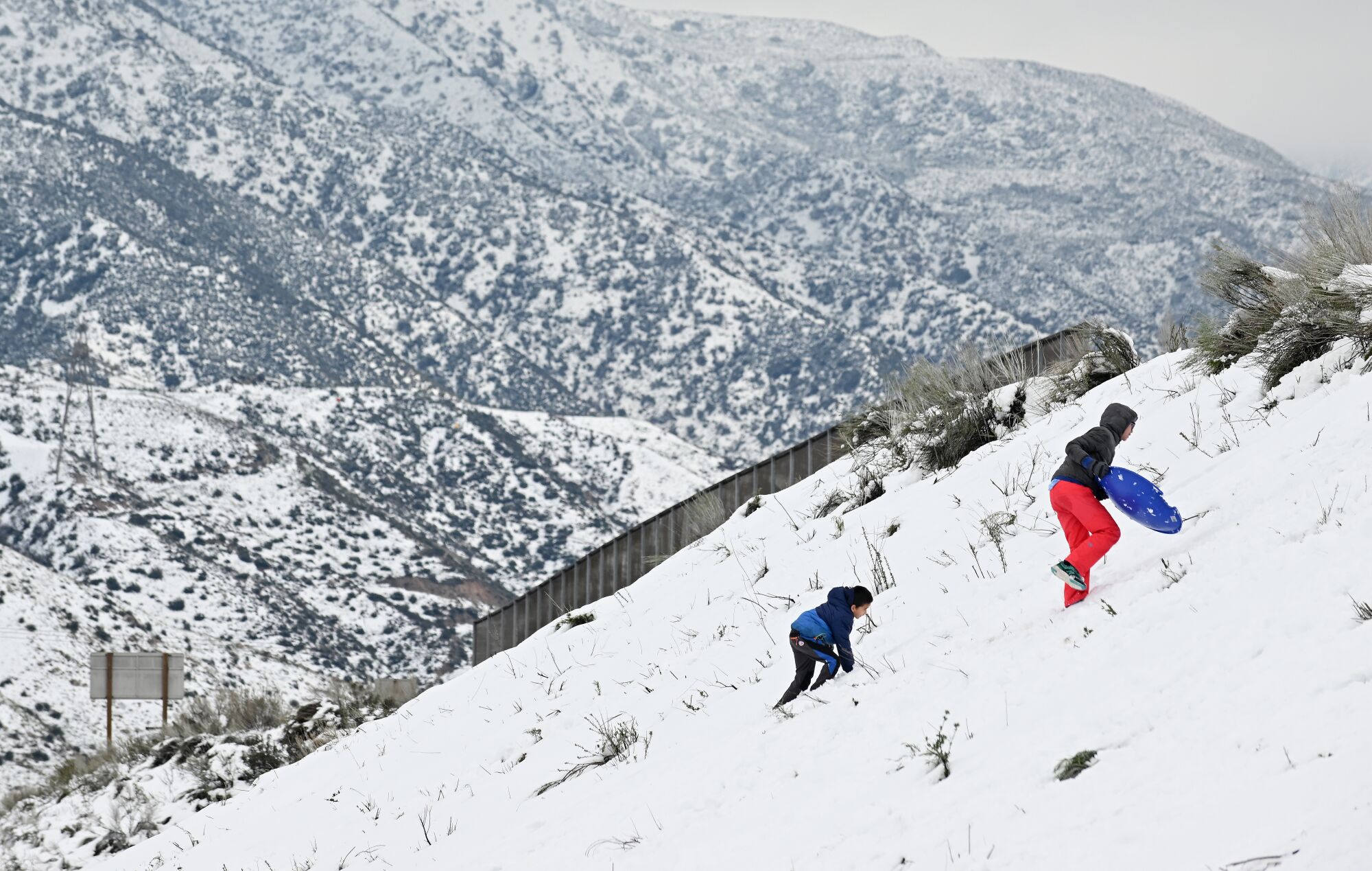 People sled along a hill on the Cajon Pass 