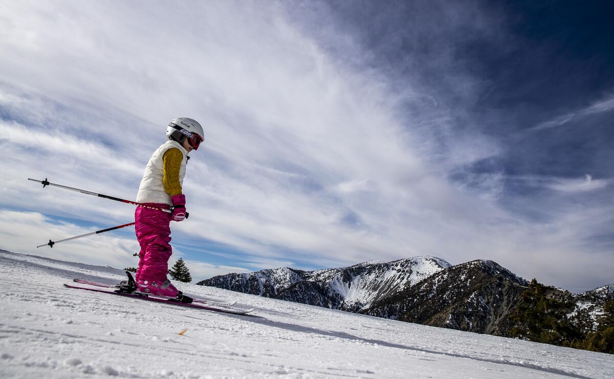 A young skier navigates a run with a view of Mt. Baldy.