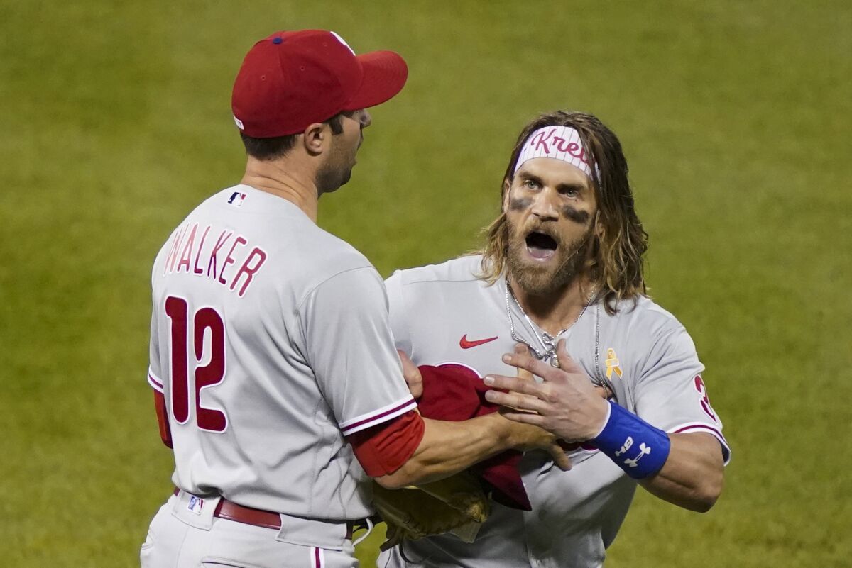 Philadelphia Phillies' Bryce Harper, right, reacts alongside Neil Walker (12) after being thrown out of the team's baseball game against the New York Mets by umpire Roberto Ortiz during the fifth inning Saturday, Sept. 5, 2020, in New York. (AP Photo/John Minchillo)