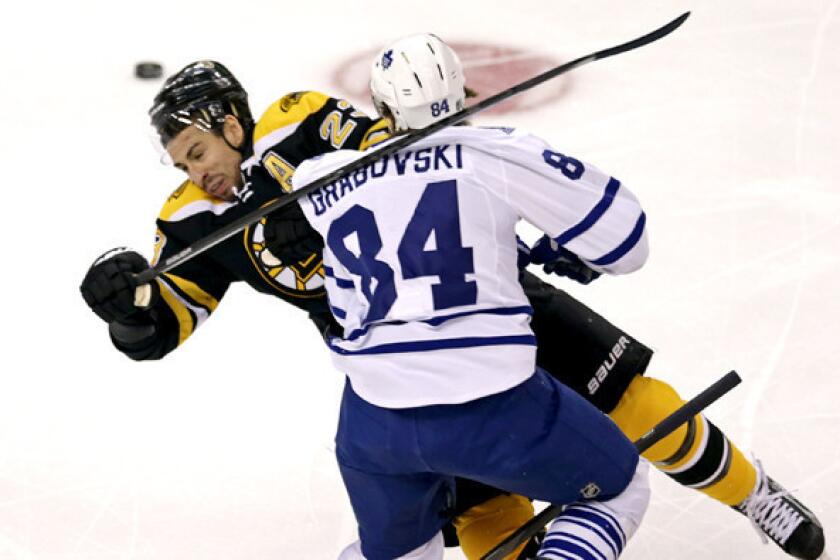 Maple Leafs center Mikhail Grabovski delivers a check against Bruins center Chris Kelly during the first period of Game 7 in their first-round playoff series.