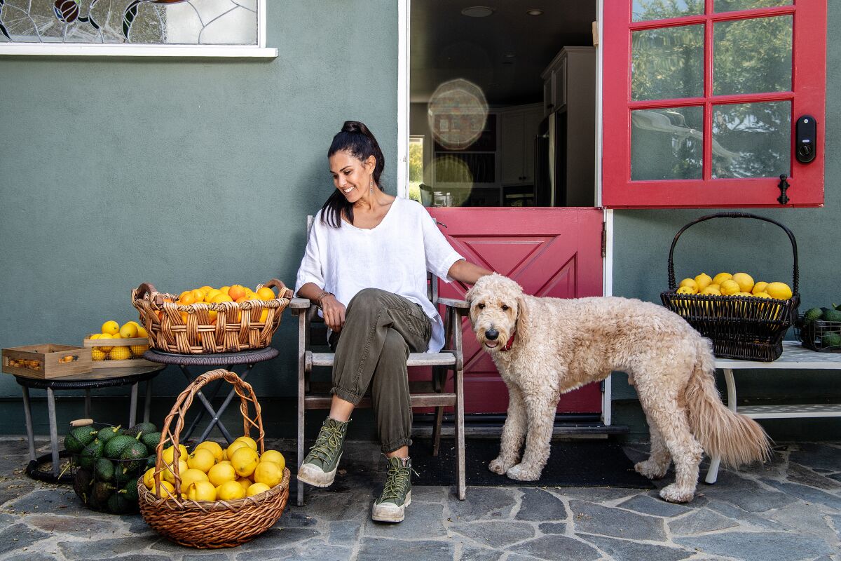 Alexandra Dorros with her dog and baskets of fruit