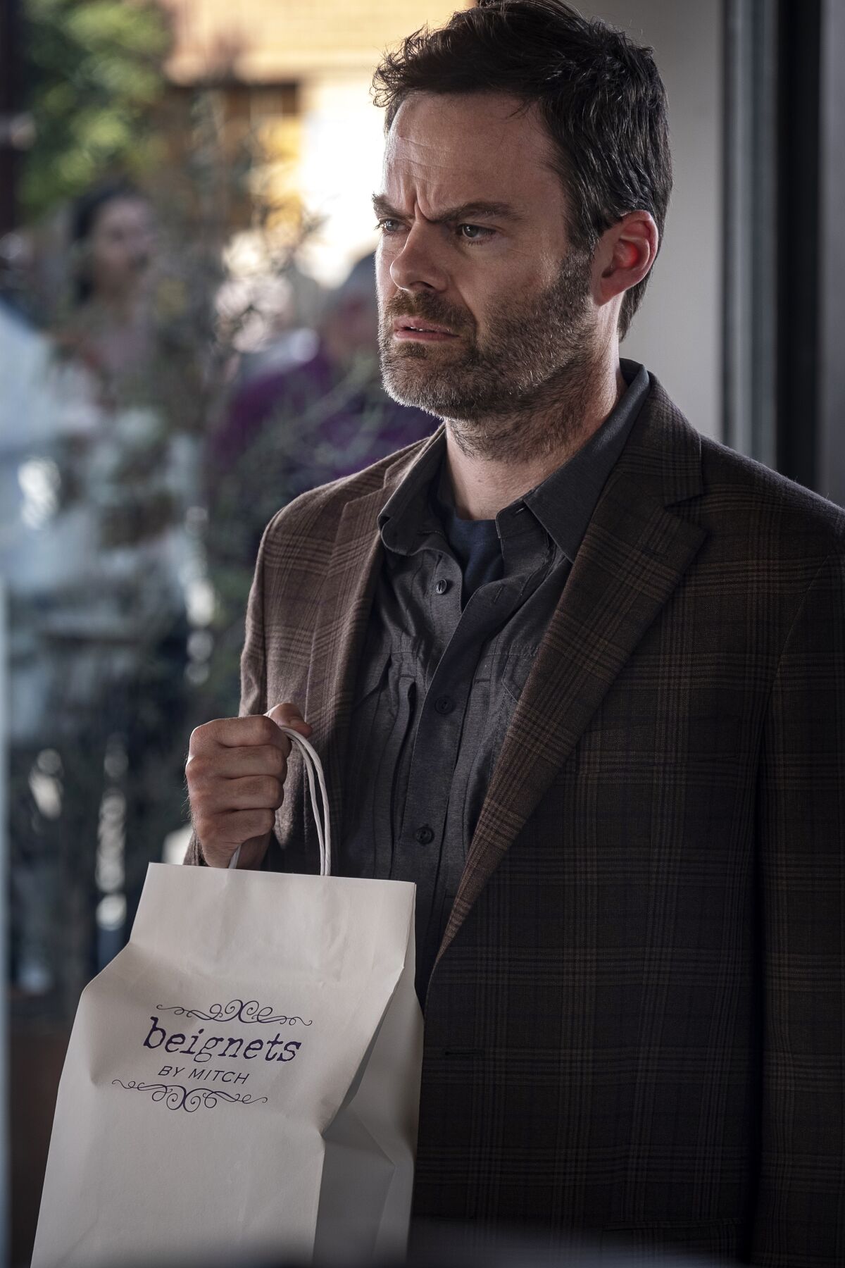 A man holds a bag of baked goods in a scene from "Barry."