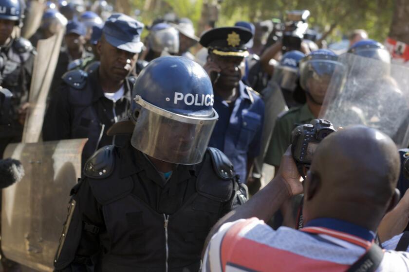 Riot police enter the Bronte hotel, where a press conference by opposition leader Nelson Chamisa was scheduled to take place, in Harare, Zimbabwe, Friday Aug. 3, 2018. Hours after President Emmerson Mnangagwa was declared the winner of a tight election, riot police disrupted a press conference where opposition leader Nelson Chamisa was about to respond to the election results. (AP Photo/Jerome Delay)