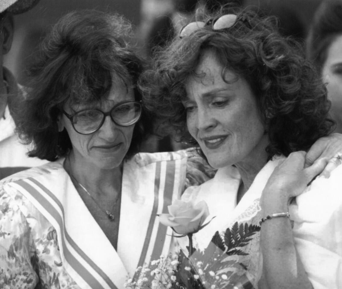 Sandy Demovsky (left) and Edie Cichowski, mother of a student who died in a drunk driving accident in 1992, attend the dedication of a memorial garden to students and teachers at Rolling Meadows High School. The idea for the garden arose when four students died in one year. The words of Lori Anderson, a student who died in a car accident in 1992 are set in a stone in the garden: "Love isn't shown through tears, but through the memories that hold together a lost life."
