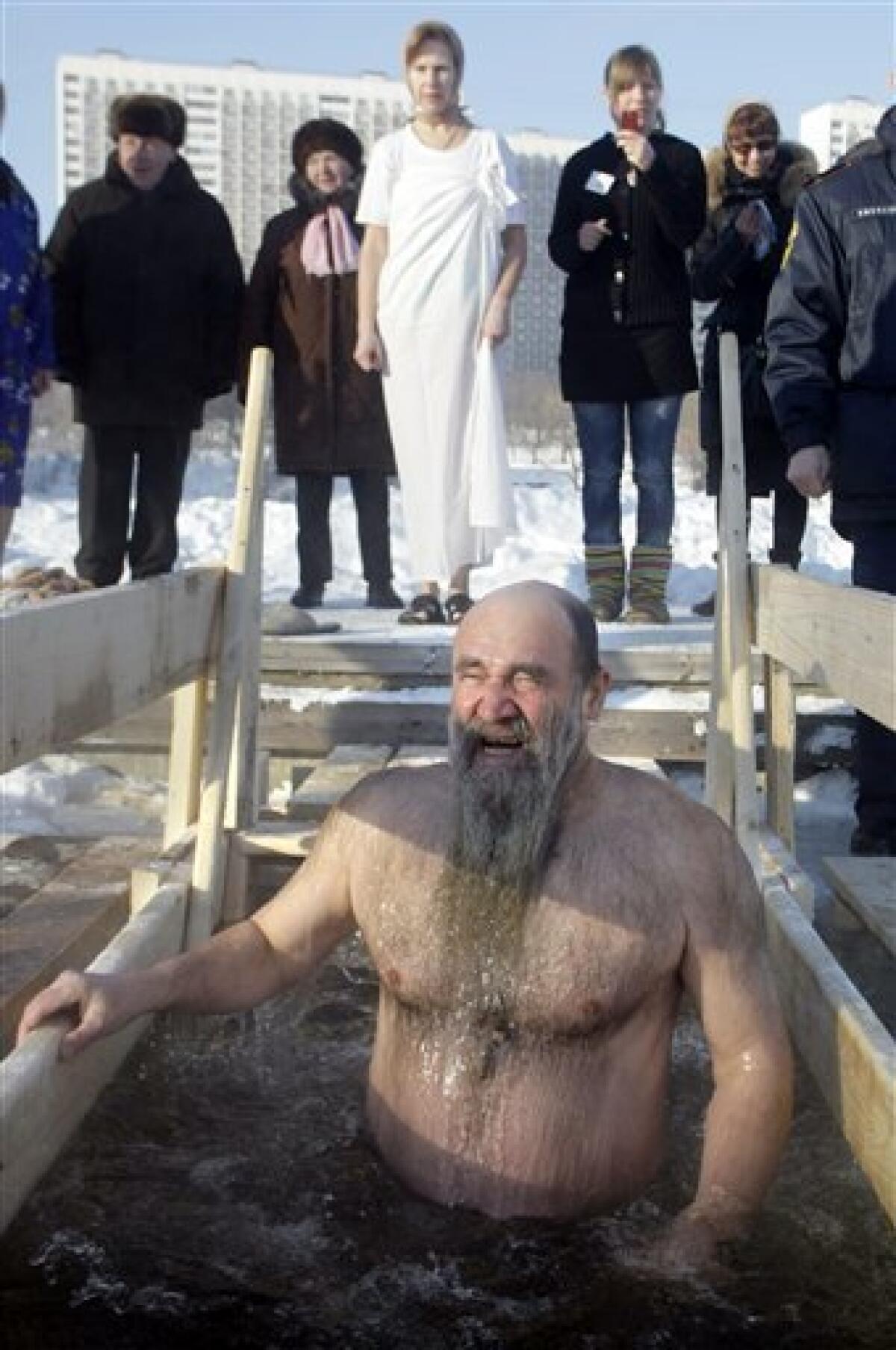 A man plunges into an icy pond to mark the upcoming Epiphany in the northwestern Moscow, Monday, Jan. 18, 2010. Thousands of Russian Orthodox Church followers plunged Monday into icy rivers and ponds across the country to mark the upcoming Epiphany, cleansing themselves with water deemed holy for the day. Water that is blessed by a cleric on Epiphany is considered holy and pure until next year's celebration, and is believed to have special powers of protection and healing. The Russian Orthodox Church follows the old Julian calendar, according to which Epiphany falls on Jan. 19. Moscow temperatures on Monday morning dropped to -20 C (-4 F). (AP Photo/Mikhail Metzel) — AP