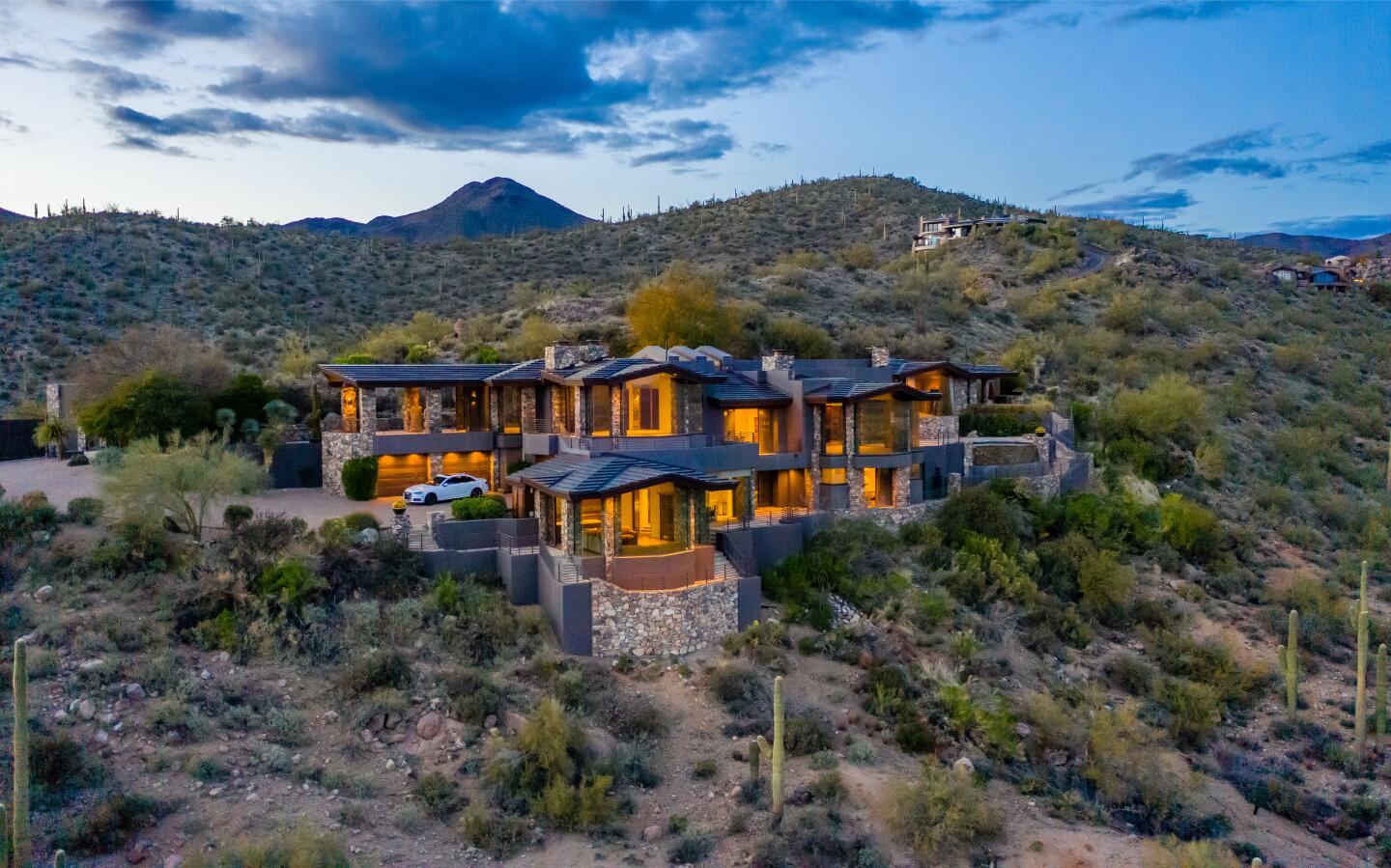 The 9,000-square-foot home seen from afar amid brush-covered hills