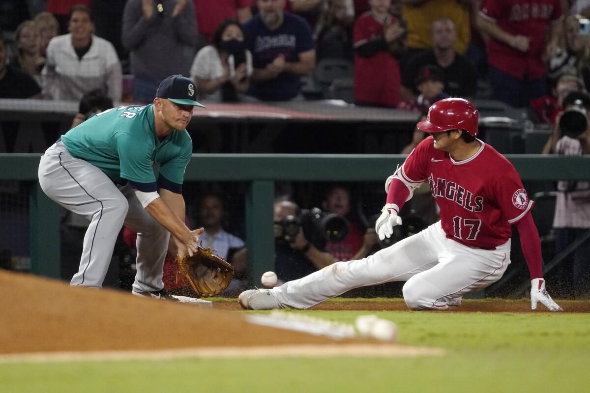 The Angels' Shohei Ohtani slides in for a third-inning triple ahead of the tag of the Mariners' Kyle Seager.