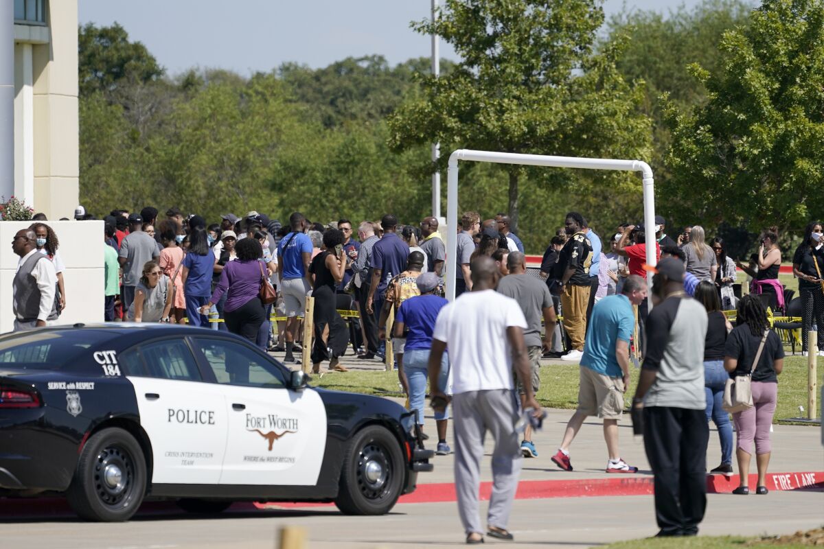 Families stand outside the Mansfield ISD Center for the Performing Arts waiting to be reunited with their children, Wednesday, Oct. 6, 2021 in Mansfield, Texas, following a shooting at the Timberview High School in Arlington. (AP Photo/Tony Gutierrez)