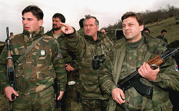 In an April 16, 1994, photo, Bosnian Serb army commander Ratko Mladic, center, observes Bosnian government forces positions in Gorazde, in eastern Bosnia. Mladic was arrested in Serbia in 2011.