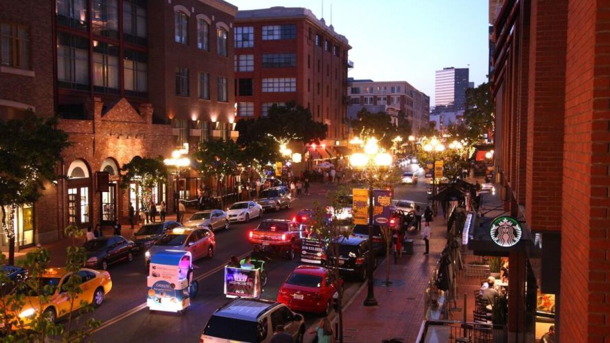 Cars drive through the Gaslamp Quarter in the evening. 