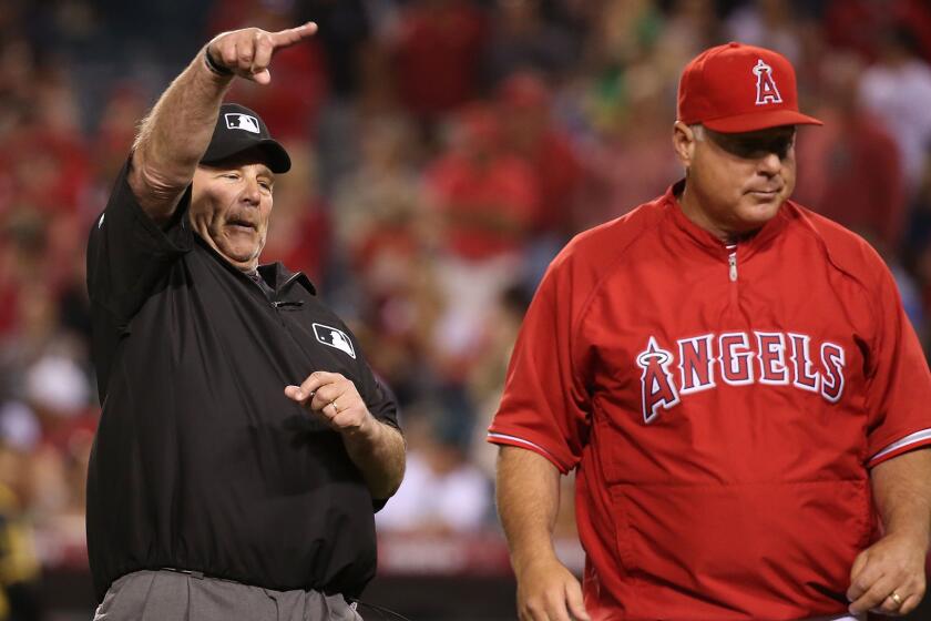 First base umpire Bob Davidson ejects Angels Manager Mike Scioscia during the fifth inning of the team's 4-1 win over the Oakland Athletics on Monday.