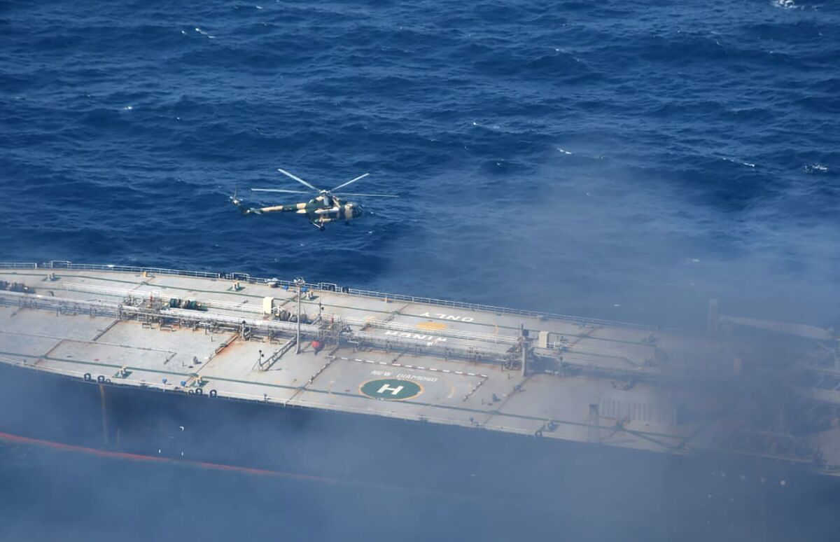 In this photo provided by Sri Lanka Air Force, a chopper flies through smoke rising from the MT New Diamond, off the eastern coast of Sri Lanka in the Indian Ocean,, Saturday, Sept. 5, 2020. The fire on the large oil tanker off Sri Lanka's coast has been brought under control but is still not extinguished, the navy said Saturday. The tanker, carrying nearly 2 million barrels of crude oil, was drifting about 20 nautical miles (37 kilometers) from Sri Lanka's eastern coast and on Friday evening a tug boat towed it to the deep sea away from land, said navy spokesman Capt. Indika de Silva. (Sri Lanka Air Force via AP)