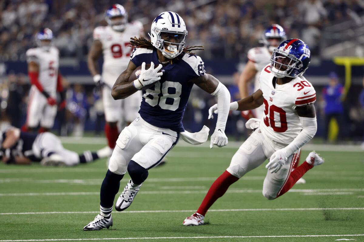Dallas Cowboys wide receiver CeeDee Lamb (88) breaks away from New York Giants cornerback Darnay Holmes (30) during the second half of an NFL football game Thursday, Nov. 24, 2022, in Arlington, Texas. (AP Photo/Ron Jenkins)