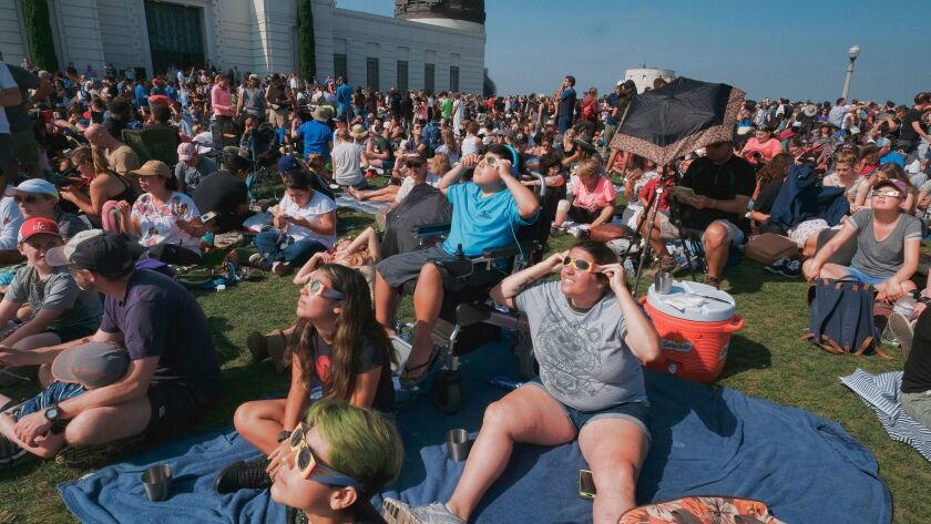 The Tinoco family from Cyprus, Calif., gather to watch the partial eclipse at the Griffith Observatory in Los Angeles on Monday.