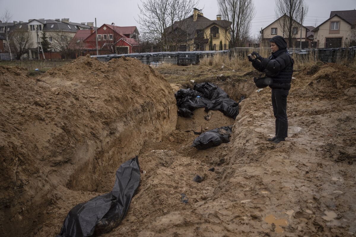 FILE - A journalist takes video of a mass grave in Bucha, on the outskirts of Kyiv, Ukraine, Sunday, April 3, 2022. Ukrainian leaders have encouraged journalists to document what is happening in the country. (AP Photo/Rodrigo Abd, File)