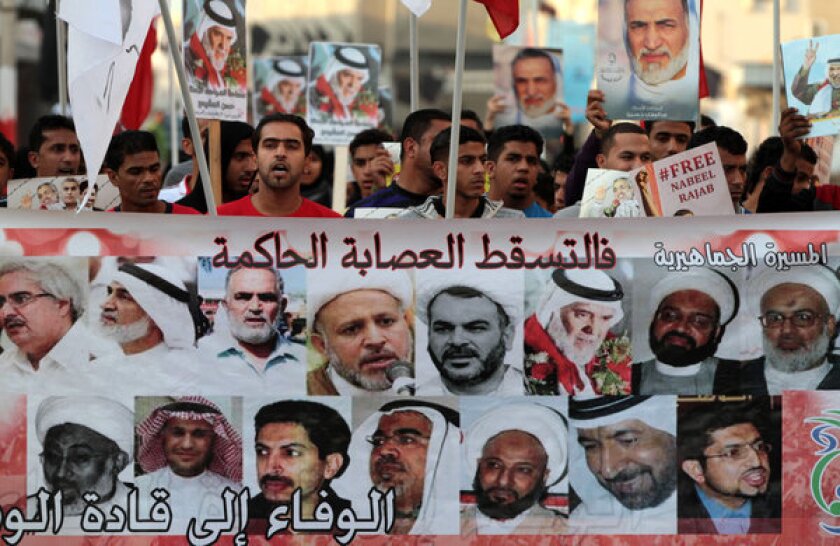 Bahraini protesters in Malkiya village chant antigovernment slogans as they hold a banner with images of jailed opposition leaders.