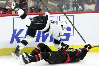 The Kings' Tanner Jeannot (10) collides with the Senators' Artem Zub (2) in the first period.