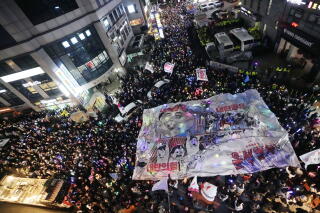 Aerial view of a crowd holding a large banner skyward