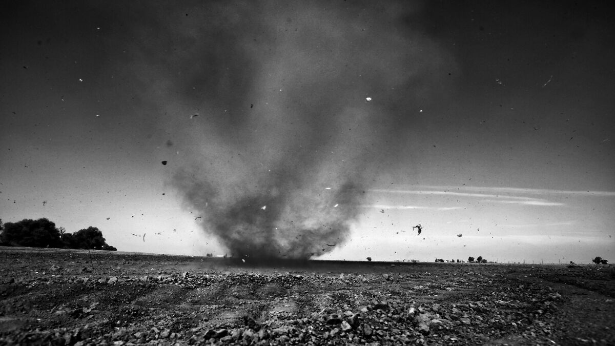 A dust devil kicks up debris as it whirls its way across a parched field on the outskirts of Stratford.