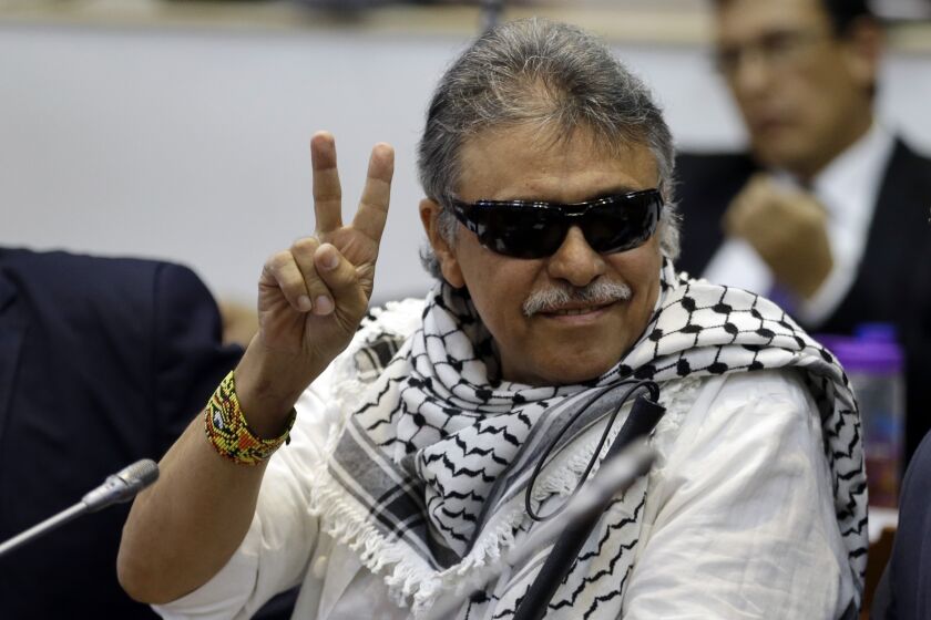 FILE - In this June 12, 2019 file photo, former FARC rebel Seuxis Hernandez, also known as Jesus Santrich, flashes a victory sign at journalists as he attends a session of the Chamber of Representatives at the Colombian congress in Bogota, Colombia. The rebel leader who abandoned a 2016 peace deal with Colombia’s government and had been at large for three years was killed in Venezuela on Monday, May 18, 2021, according to a statement published by his new armed movement. (AP Photo/Fernando Vergara, File)
