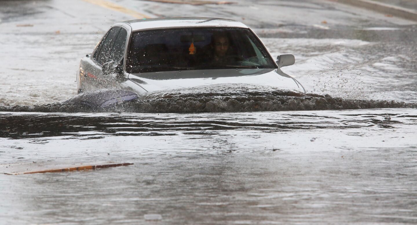 A driver braves a flooded section of Avenue 26 in Lincoln Heights in Los Angeles, Calif.