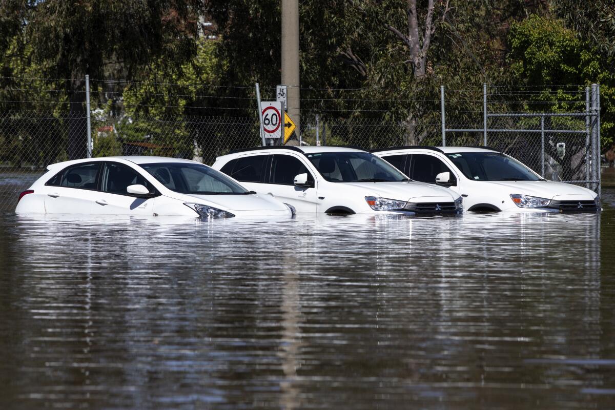 A trio of cars are stuck in floodwaters in Shepparton, Australia, Monday, Oct. 17, 2022. Around 34,000 homes could be inundated or isolated in Victoria state as a flood emergency continues across parts of Australia's southeast, an official said. (Diego Fedele/AAP Image via AP)