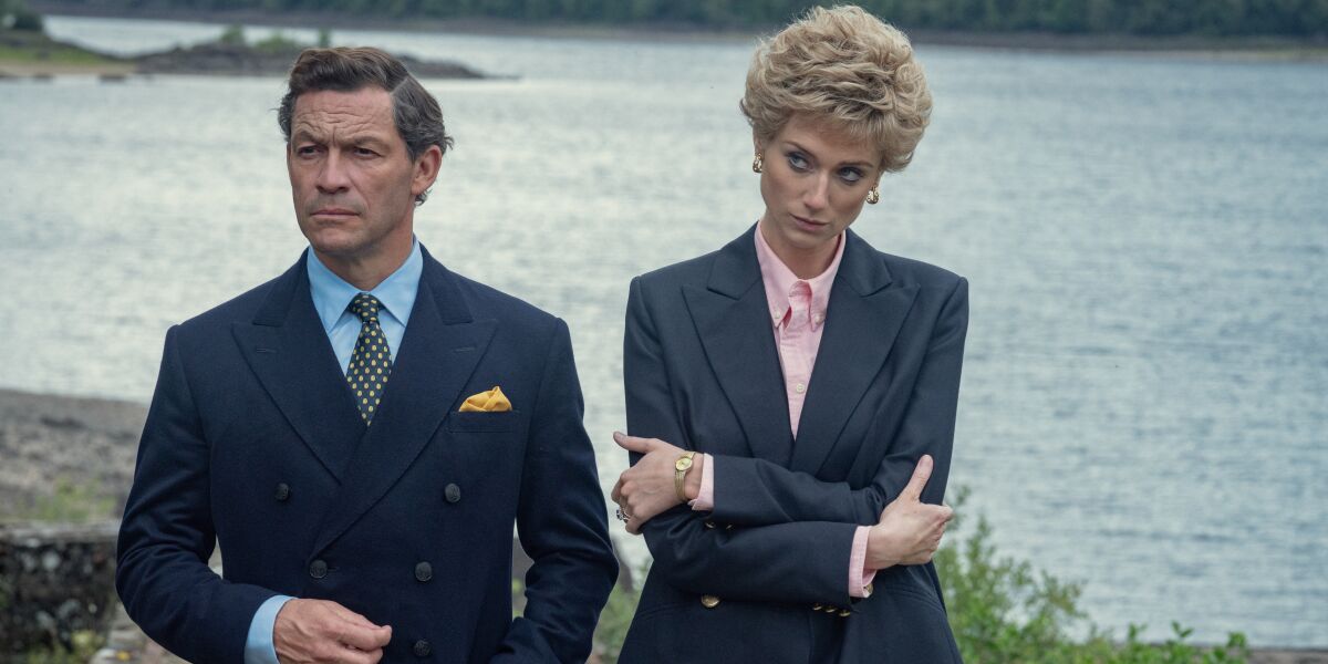 A man and a woman in suits look glum in the TV series "The Crown."
