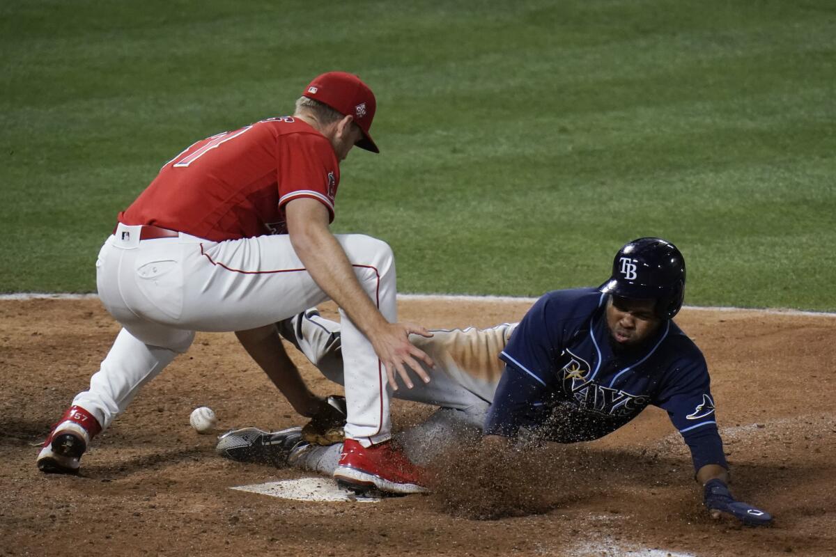 Tampa Bay Rays' Manuel Margot steals home to score as Angels pitcher Aaron Slegers misses the throw.