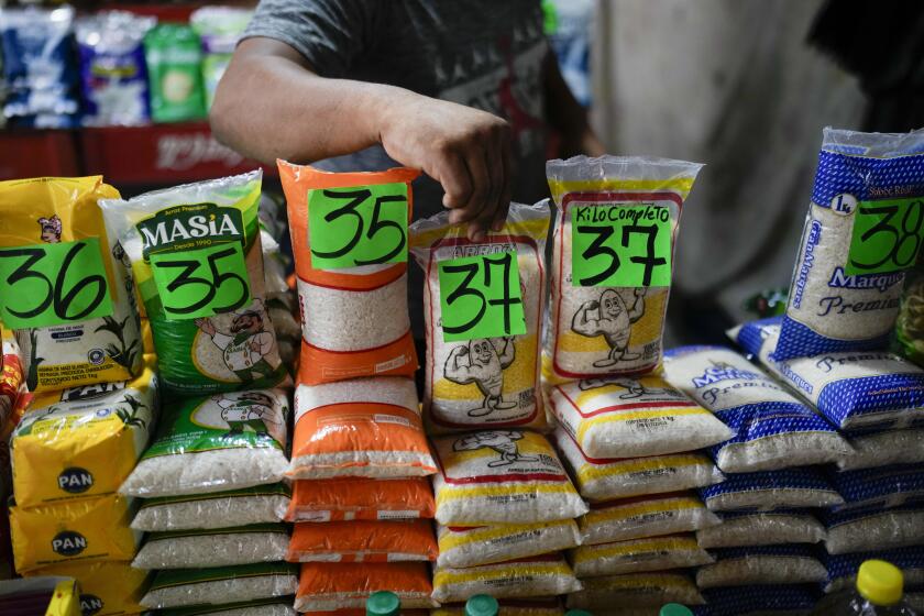 Un comerciante coloca arroz a la venta en el mercado en Maracaibo, Venezuela, el lunes 22 de julio de 2024. El país va a elecciones presidenciales el domingo 28 de julio. (AP Foto/Matías Delacroix)