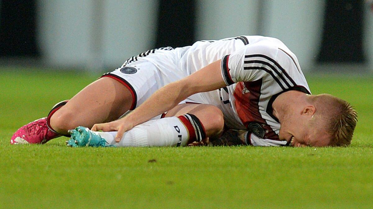 Germany's Marco Reus holds his left ankle after twisting it during an international friendly match against Armenia on Friday. Reus will not play in the World Cup because of the injury.