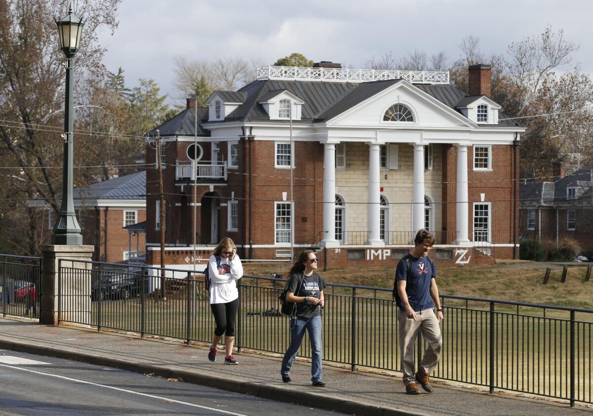 University of Virginia students walk to campus on Nov. 24 past the Phi Kappa Psi fraternity house at the University of Virginia in Charlottesville, Va.
