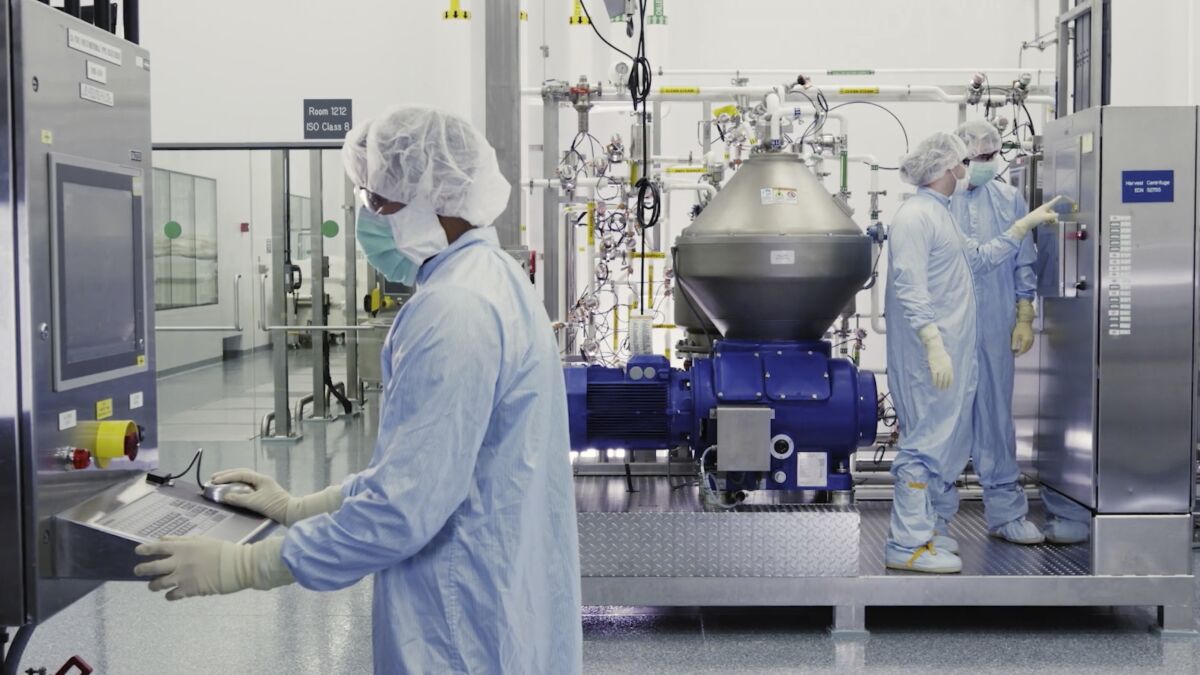 In an image from video, scientists work with a bioreactor at a Regeneron Pharmaceuticals facility in New York.
