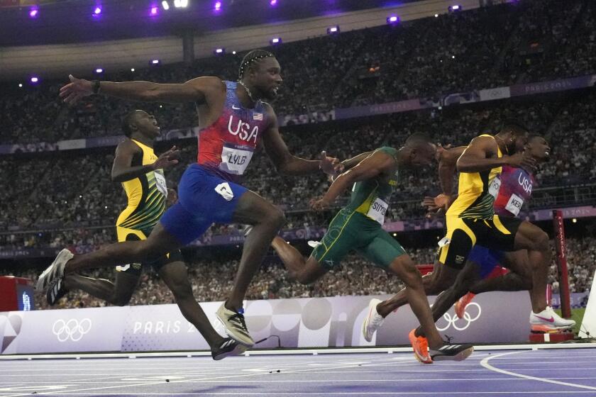 El estadounidense Noah Lyles se estira para ganar la final de los 100 metros de los Juegos Olímpicos de París, el domingo 4 de agosto de 2024, en Saint-Denis, Francia. (AP Foto/Petr David Josek)