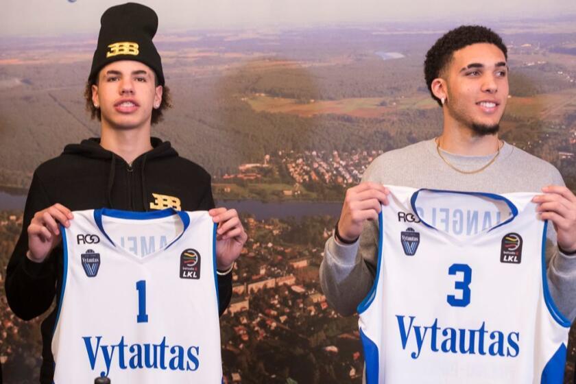 American basketball players LiAngelo Ball, right, and his brother, LaMelo, show their shirts after signing for Lithuanian team BC Prienai - Birstonas Vytautas, during a news conference at the Harmony park hotel in Vaizgaikiemis village, Prienai district, Lithuania, Friday, Jan. 5, 2018. LiAngelo Ball and LaMelo Ball signed a one-year contracts to play for Lithuanian professional basketball club Prienai - Birstonas Vytautas in the southern Lithuania town of Prienai, some 110 km (68 miles) from the Lithuanian capital Vilnius.(AP Photo/Mindaugas Kulbis)