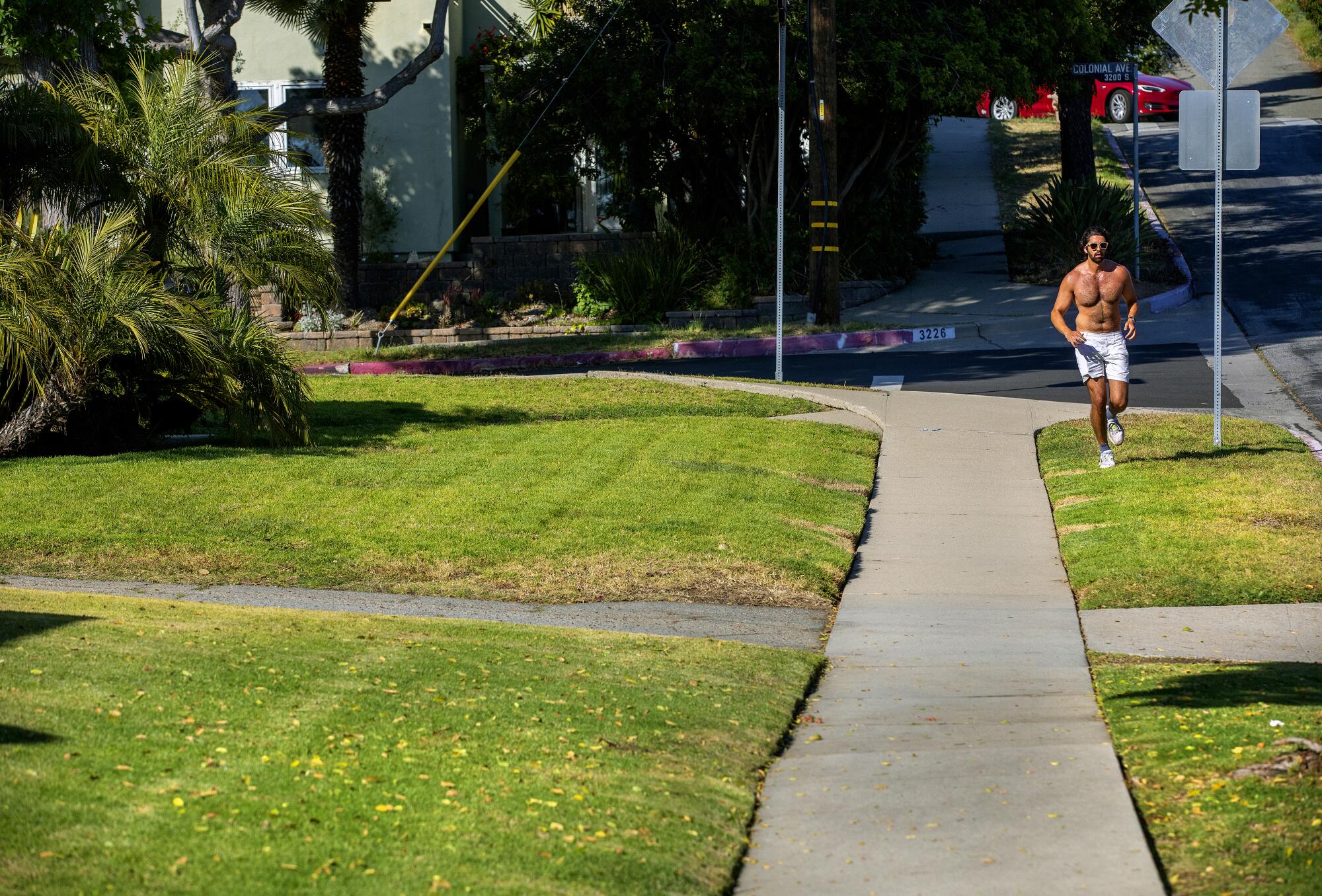A jogger runs by homes with green lawns on Rose Avenue in Mar Vista. 