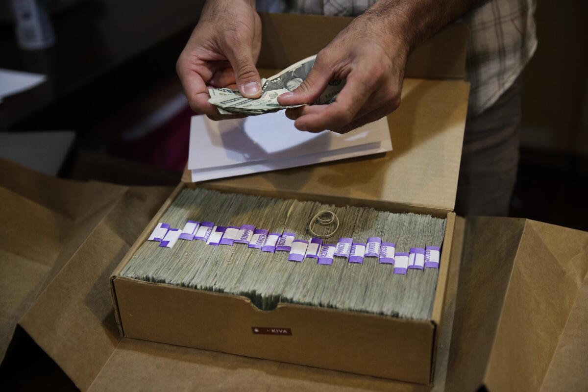 In file photo, the owner of a medical marijuana dispensary in Los Angeles prepares his monthly tax payment -- paid in cash because of a lack of access to financial services.
