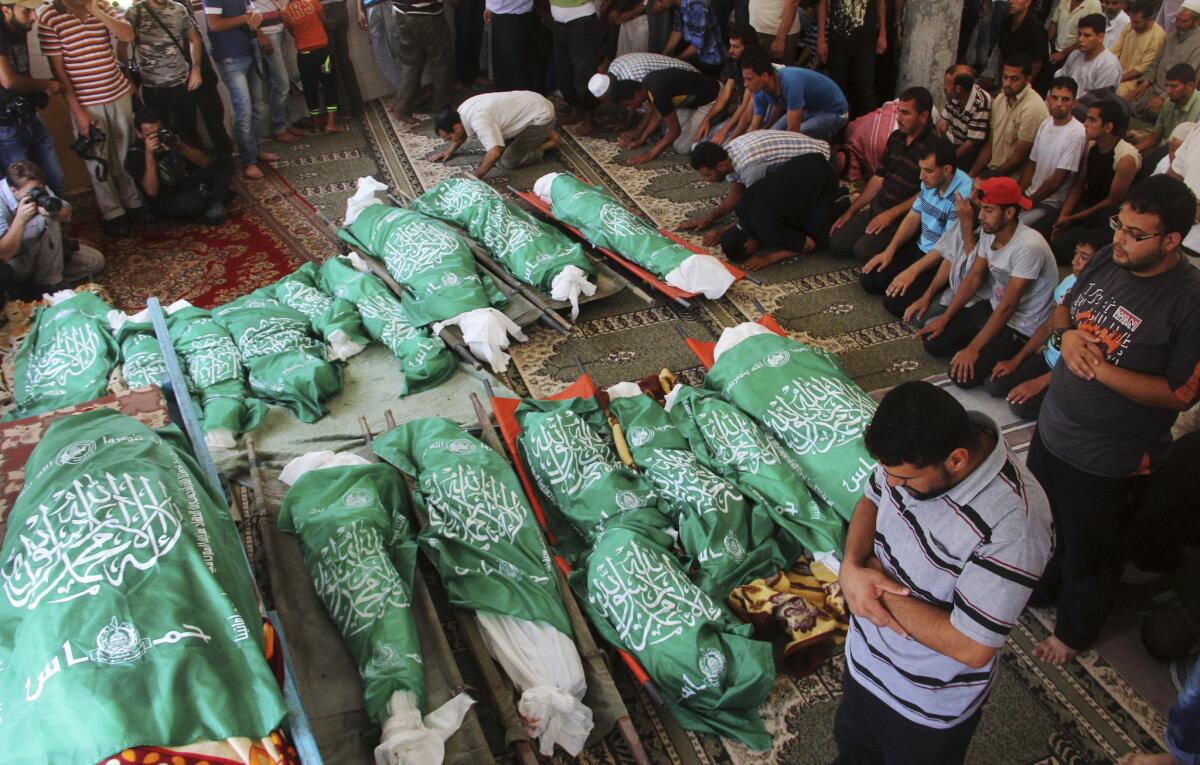 Palestinians pray July 21 over the bodies of a group of family members killed in an Israeli airstrike at their house in the southern Gaza Strip.