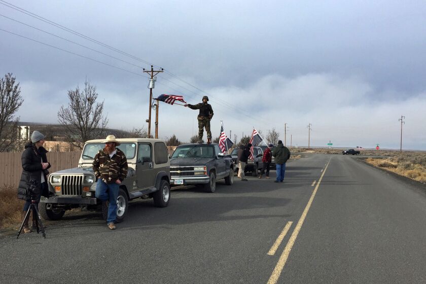 People wave American flags near the Malheur National Wildlife Refuge in Oregon as negotiations were underway that led to the surrender of the last four occupiers.