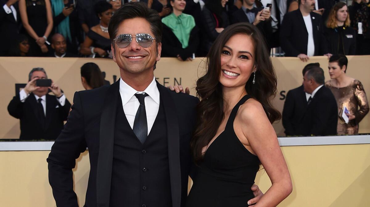 John Stamos, left, and Caitlin McHugh arrive at the 24th annual Screen Actors Guild Awards at the Shrine Auditorium & Expo Hall in Los Angeles on Jan. 21, 2018