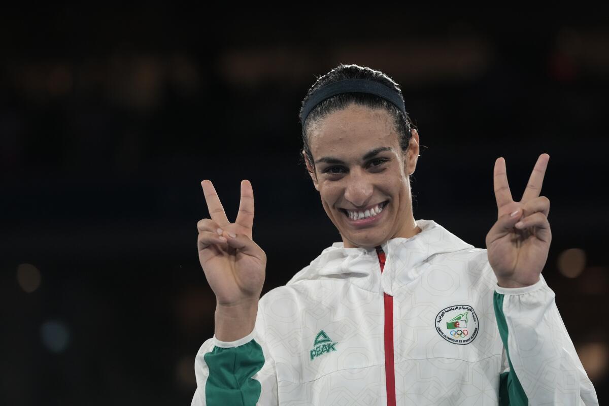 Alegerian boxer Imane Khelif makes a "V" gesture with both hands.