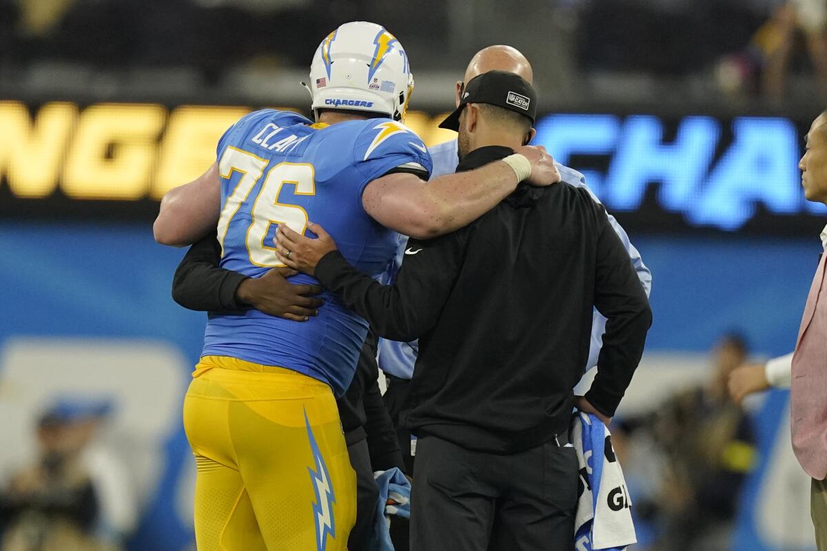 Chargers center Will Clapp is helped off the field after sustaining an injury in the fourth quarter.
