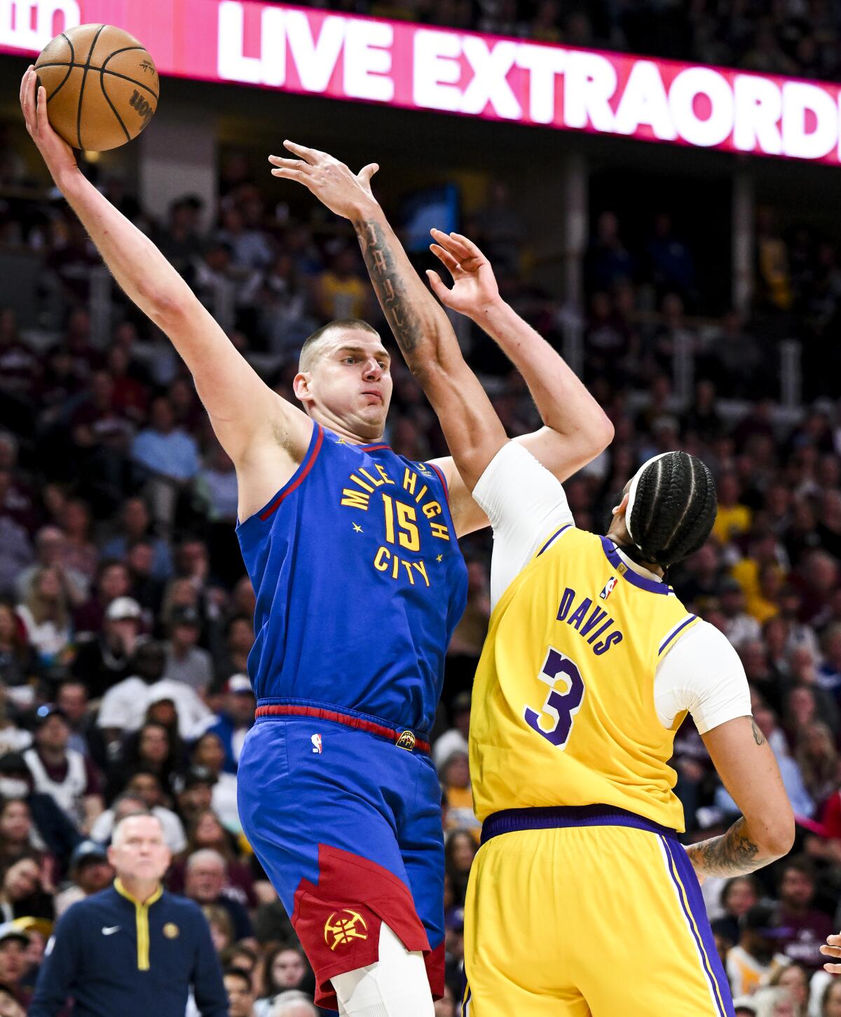 Nuggets center Nikola Jokic, left, tries to loft a shot over the outstretched left arm of Lakers forward Anthony Davis.