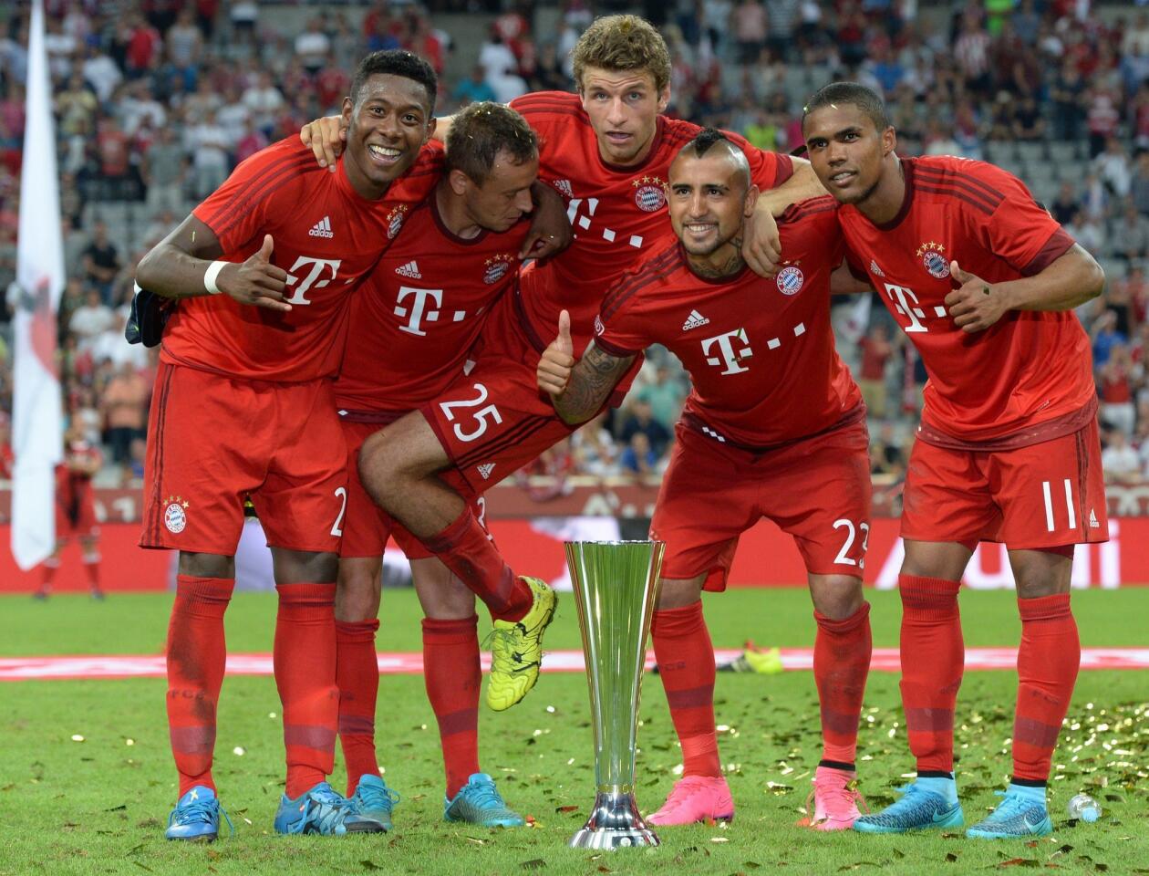 (L-R) Bayern Munich's Austrian defender David Alaba, Bayern Munich's Brazilian defender Rafinha, Bayern Munich's striker Thomas Mueller, Bayern Munich's Chilean midfielder Arturo Vidal and Bayern Munich's Brazilian midfielder Douglas Costa joke with the trophy after the Audi Cup final football match Real Madrid vs FC Bayern Munich in Munich, southern Germany, on August 5, 2015. Bayern Munich won the match 1-0. AFP PHOTO / CHRISTOF STACHECHRISTOF STACHE/AFP/Getty Images ** OUTS - ELSENT, FPG - OUTS * NM, PH, VA if sourced by CT, LA or MoD **